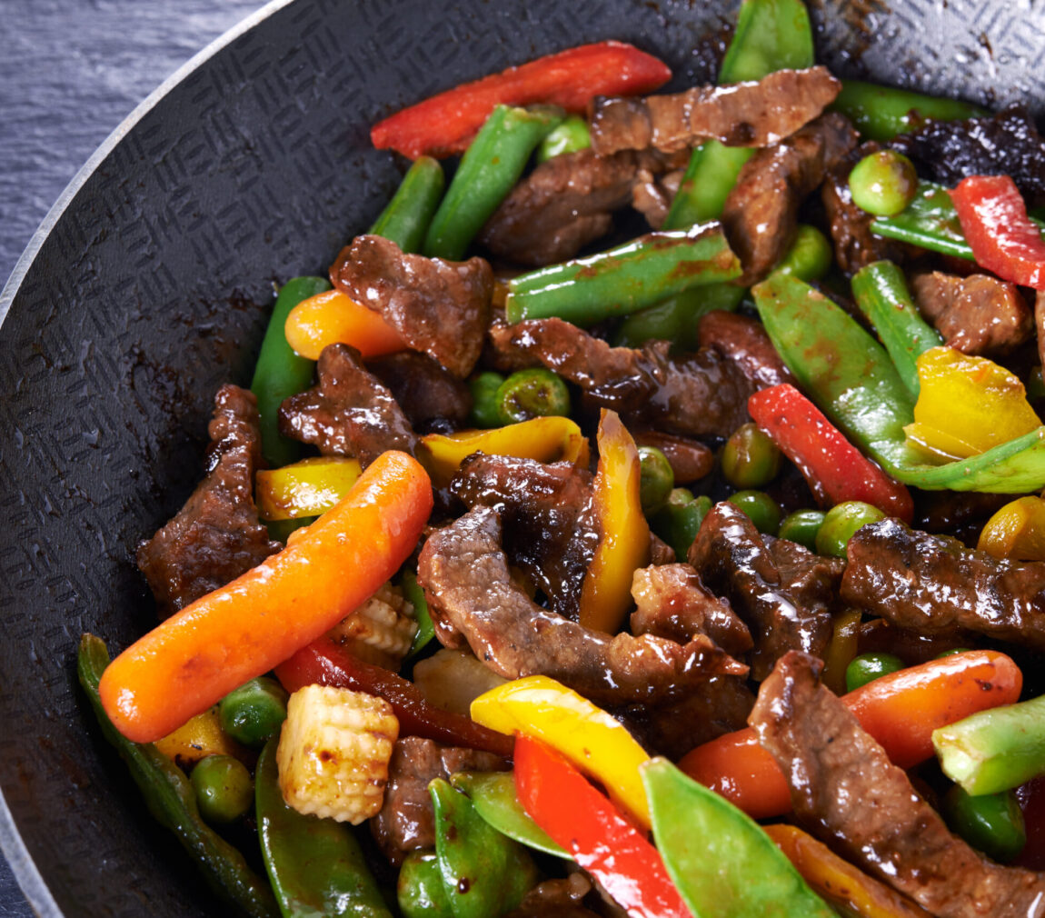 pan with stir fried beef and vegetables close up