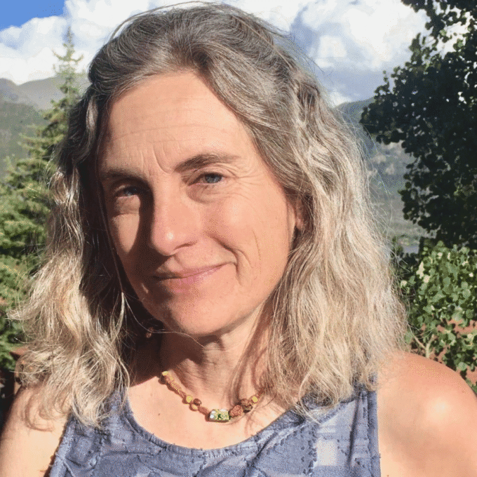 Woman smiling outdoors with mountain scenery